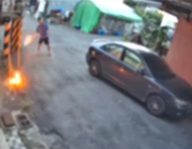 叶姓男子先在住家楼下附近点火，再将已着火的汽油罐往邻居家二楼丢。(吕妍庭翻摄)