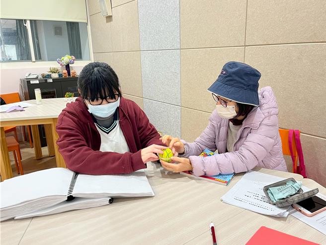 彰化溪湖高中全盲视障生林歆璇（左），藉由触摸模型与教具学习数学。（溪湖高中提供／叶静美彰化传真）