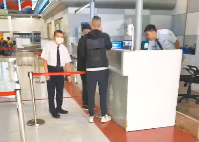 前台南市副市长顏纯左的儿子顏大钧（戴帽者）疑似在保镳陪同下，准备从高雄小港机场出境时，被查出遭境管未能离境。（民眾提供／郭良杰台南传真）