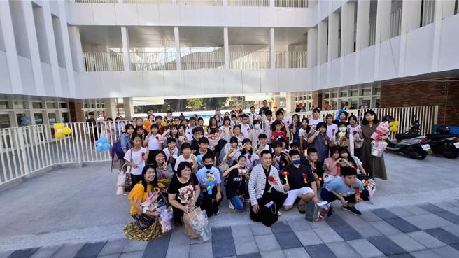 台南市中西区成功国小应届毕业生与老师一起回母校举办毕业典礼，在校门口合影。（程炳璋摄）