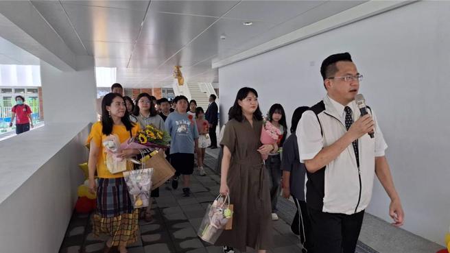 台南市中西区成功国小校长陈建铭（右一）14日下午带着应届毕业生与家长一起回母校作毕业巡礼，介绍校舍。（程炳璋摄）