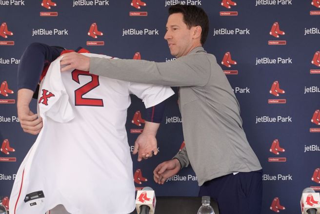 紅襪棒球執行長布雷斯洛(右)為新加盟的三壘手布瑞格曼披上球衣。(美聯社資料照)