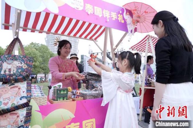 2025年5月10日，「豫见泰浪漫——2025年泰国旅游文化推广活动」在河南郑州艺术中心文化广场启幕。图为市民选购泰国伴手礼布艺小象。 中新社