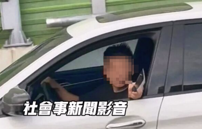 一輛白色BMW轎車蛇行擋路，駕駛還持開山刀伸出車外咆哮。（翻攝社會事新聞影音）