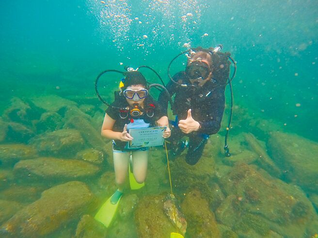 基隆市中华国小举办潜水毕业典礼，学生背起气瓶潜入海中「捞」出自己的毕业证书。（基隆市中华国小提供／张志康基隆传真）