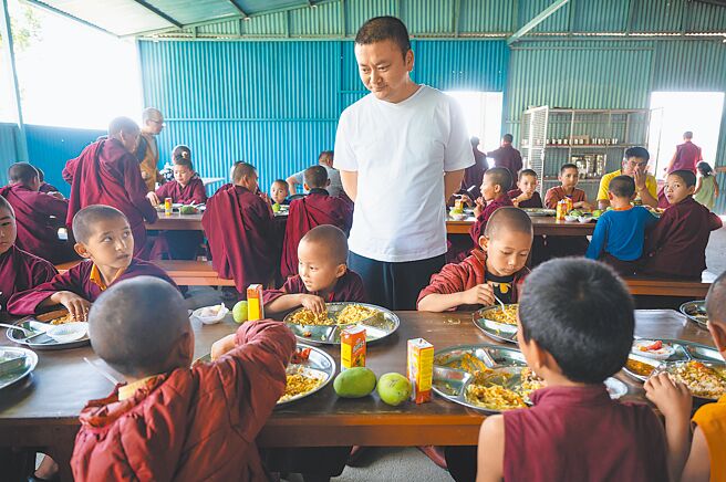 仁波切巡视孩子们的午餐。（摄影／林彦廷）