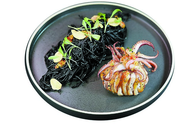 「清炒墨魚麵／炙燒小卷／炸蒜片」是「瑪黑餐酒．敦南店」主廚Kris江承恩早年在義式料理廚房所習，揉合經典與維也納風情。圖／姚舜
