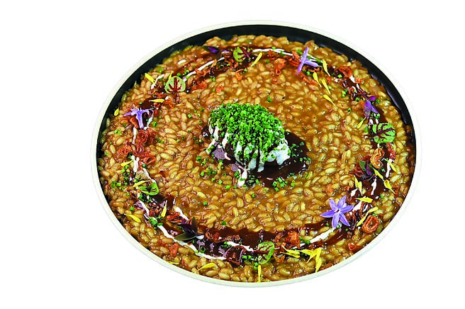 西班牙主廚Dani Palm做的「慢燉豬頰肉燉飯／黑巧克力醬汁／蒜奶醬」，結合了義大利燉飯、西班牙海鮮飯，以及墨西哥巧克力料理和加泰隆尼亞豬肉美食的特色於一盤。圖／姚舜