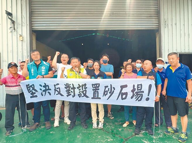 台中市大里区草堤路业者拟设砂石碎解洗选场，西湖里长赖加彬（前排右二）20日率居民拉白布条抗议。（潘虹恩摄）