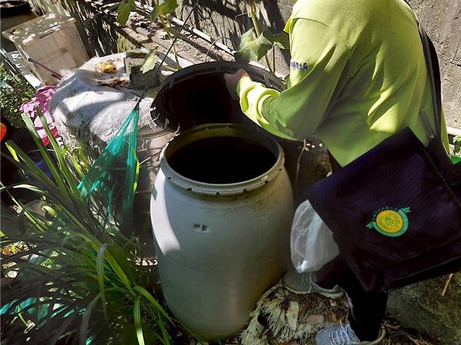 防疫人員針對菜園水桶進行孳生源查核。（高雄市政府衛生局提供／林雅惠高雄傳真）