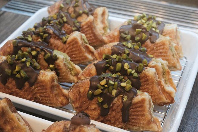 「可頌鯛魚燒」以可頌麵皮取代原本的奶蛋麵皮，內餡以法式卡士達的手法調配，主廚將內餡外露創造視覺效果，也融入絲滑爆漿的豐富口感，成為江南甜點圈的指標性產品。（台北晶華酒店提供）