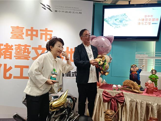 市長盧秀燕（左）與麗明董事長吳春山（右）兩人特別將豬藝品捧在手上把玩。（陳淑娥攝）