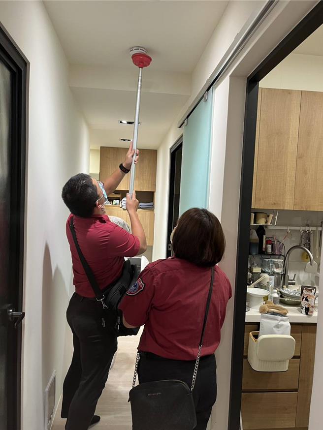 消防队员检查住警器。（新北市消防局提供）