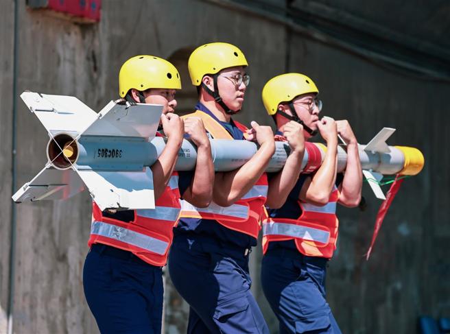  武挂人员搬运实施装挂作业，将AIM-9P4响尾蛇飞弹安装至派龙架。（记者谢承宏摄）