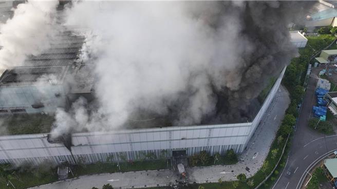 三元能源科技公司高雄鋰電廠14日火災釀15傷，因廠內有大量鋰電池，火勢難以直接撲滅，消防只能在火場旁灑水降溫戒護。（消防提供／紀爰高雄傳真）