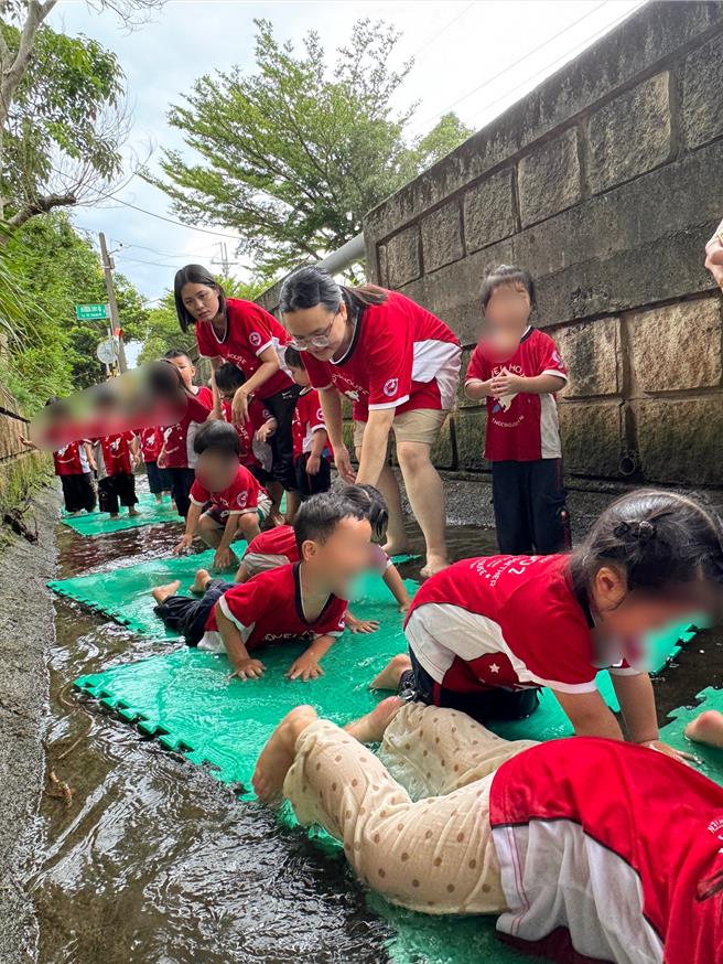 桃園市新屋區新奇屋幼兒園為了讓幼生體驗農民生活，連續超過20年帶幼生至桃園大圳灌溉水圳戲水。14日趁新屋區今年第1期作完成供灌，圳路僅剩少量水源，園方帶約200名孩童下水圳遊憩。(園方提供)