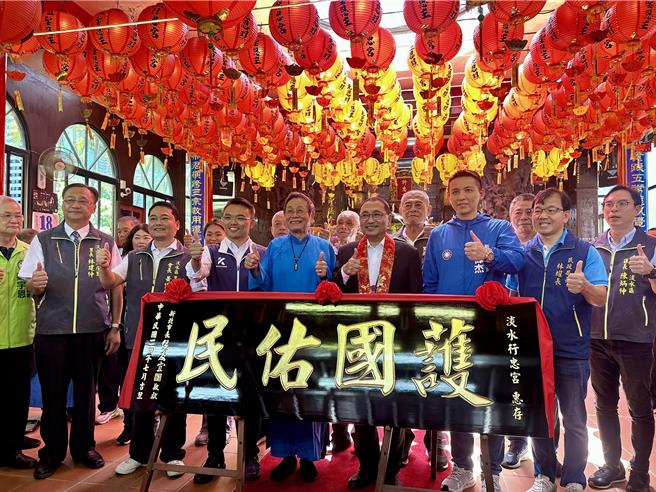 市长侯友宜(右四)到淡水行忠宫参拜，赠「护国佑民」匾额予庙方，主委黄德利(左五)代表受赠。（新北市民政局提供）