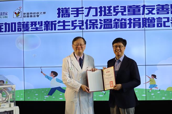 新竹台大分院院長余忠仁（左）頒贈感謝狀予麥當勞叔叔之家慈善基金會董事長李昌霖，感謝基金會捐贈重症加護型新生兒保溫箱，攜手守護新生命。（邱立雅攝）