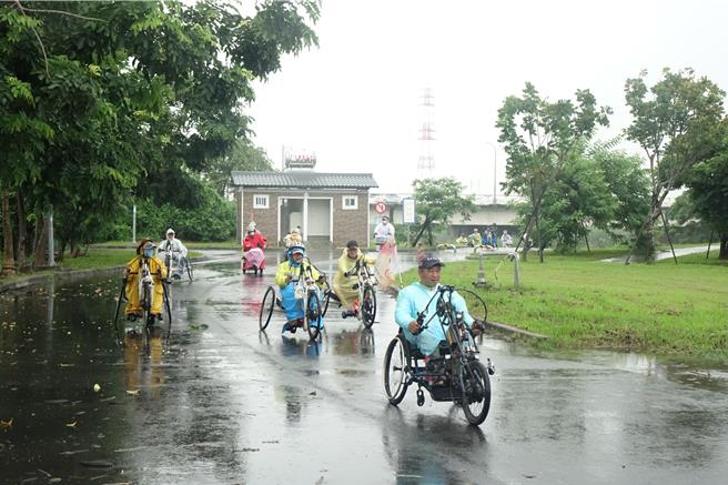 云林爱无碍协会车队在风雨中沿东港溪来到潮州着名地标戎克船。（罗琦文摄）