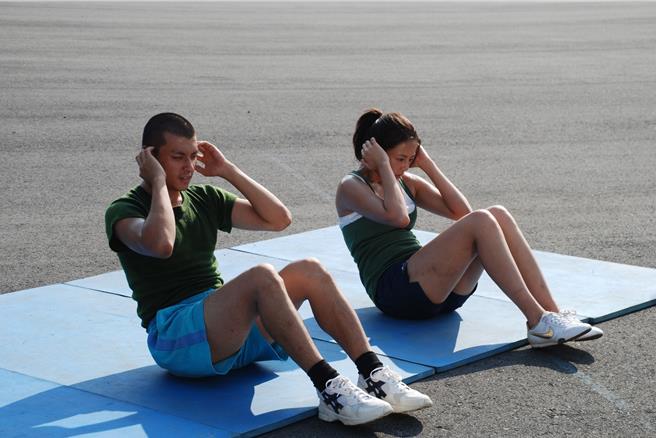 劉香慈(右)與唐豐(左)當時拍《新兵日記》在豔陽下做仰臥起坐。(民視提供)