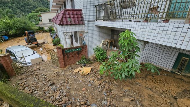 埔里墘溪路後方山區爆發土石流，屋外土石掩埋逾2公尺、近1層樓高，停放庭園轎車也遭殃。（埔里鎮公所提供／楊靜茹南投傳真）