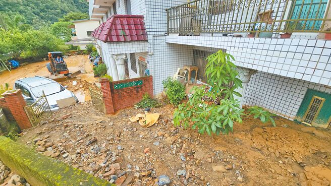 南投縣埔里鎮墘溪路後方山區21日晚間爆發土石流，民宅屋外土石掩埋逾2公尺、近1層樓高，停放在庭園的轎車也遭殃。（埔里鎮公所提供／楊靜茹南投傳真）