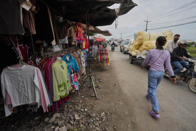 柬埔寨廉价劳力充足，近年已成美国品牌服装生产基地之一。图为首都金边市郊成衣厂女工午休外出，行经当地为女工开设的市集。照片摄于今年7月8日。（资料照／美联社）