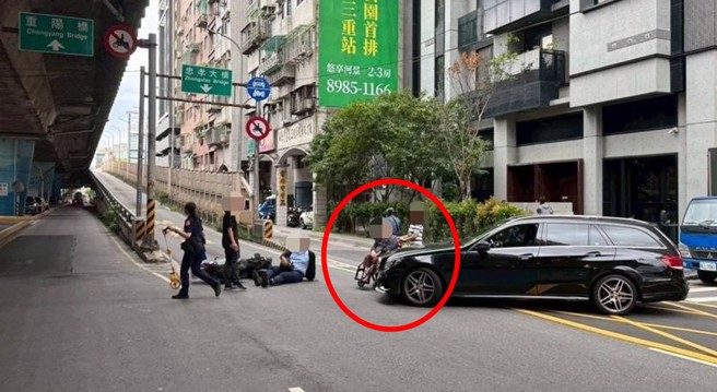 車禍發生後，汽車駕駛下車坐輪椅查看車禍及對方傷勢。（三重警分局提供）