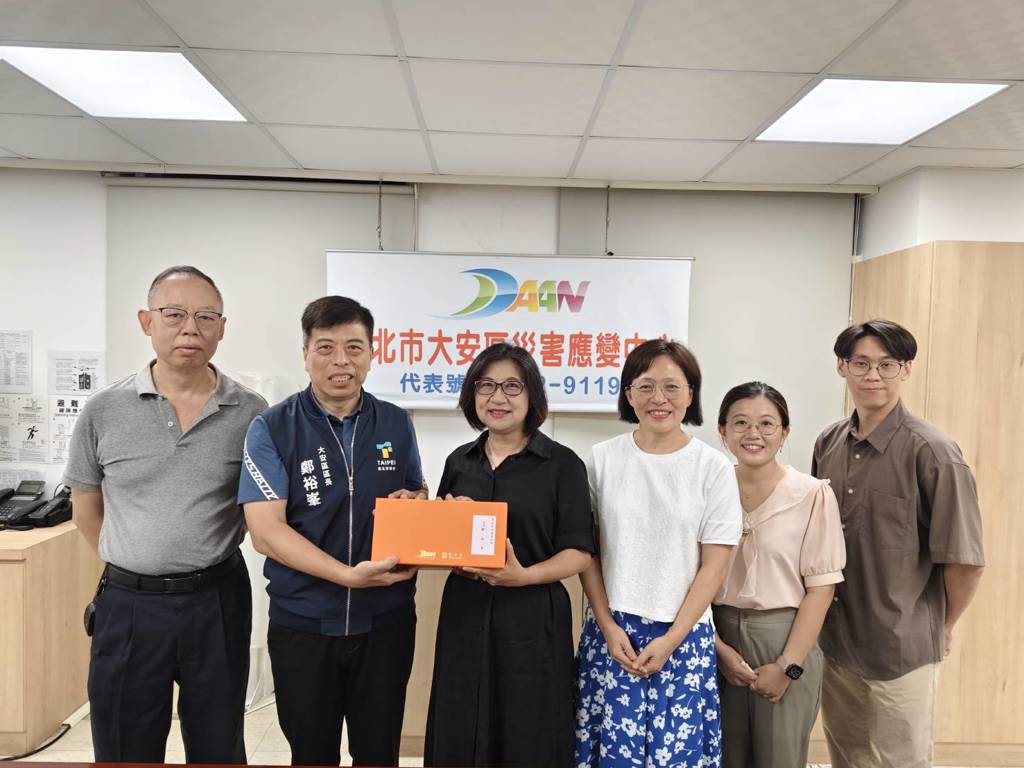 鄭裕峯區長致贈紀念品，大安區公所王治業主任秘書(左一)、臺師大林玫君學務長(右四)、心田心理諮商所王玉珍主任(右三)及同仁。(大安區公所提供)