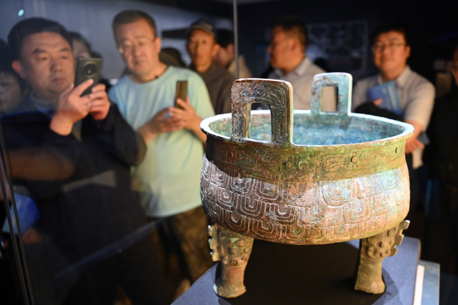 2025年5月18日，甘肅蘭州，「問秦——甘肅秦文化考古二十年成果特展」在甘肅簡牘博物館開展。圖為觀眾參觀垂鱗紋秦公鼎。 中新社