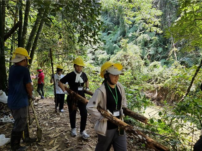 日本龙谷大学与台中科技大学体验手作步道，合力搬运风倒木。（林保署南投分署提供／杨静茹南投传真）