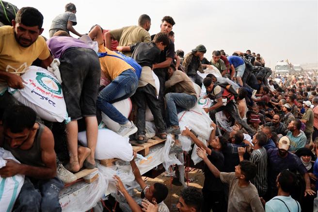 欧盟与26国外长发表联合声明，直指加萨人道危机空前严峻，要求以国批准无限制援助行动。图为加萨民眾争相领取援助物资。（达志影像／路透社）