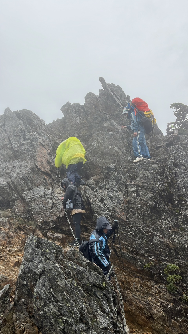 2名山友登玉山東峰遇冷心高壓過境下雷陣雨，疑遭雷擊受傷；排雲山莊人員在鳳尾岩接觸到患者，護送傷患下徹。（玉山國家公園提供／楊靜茹南投傳真）