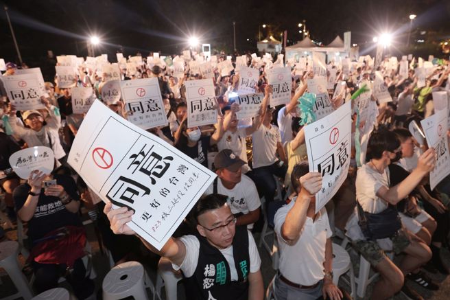 台灣民眾黨22日舉行公投之夜 Taiwan Restart，參與民眾高舉「同意」的標語。（杜宜諳攝）