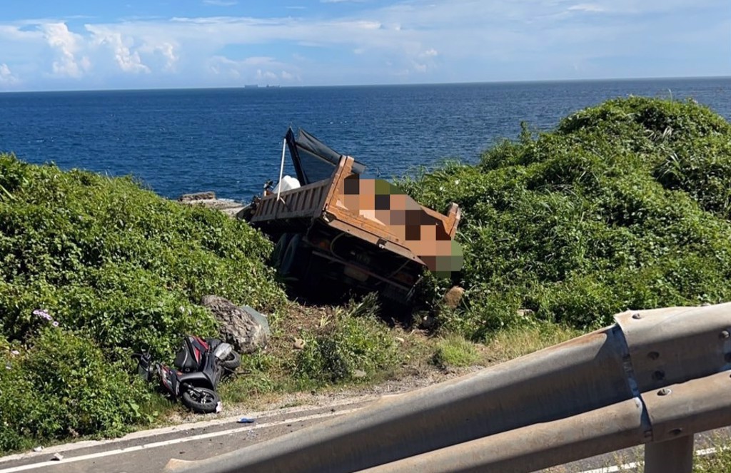今天（26日）上午發生一起驚悚的死亡車禍！一輛砂石車與自小客車發生猛烈對撞，砂石車當場被撞到衝破護欄，卡在邊坡草叢中，55歲張簡姓男駕駛受困車底，當場失去生命跡象，救護人員到場搶救仍回天乏術。（翻攝記者爆料網）
