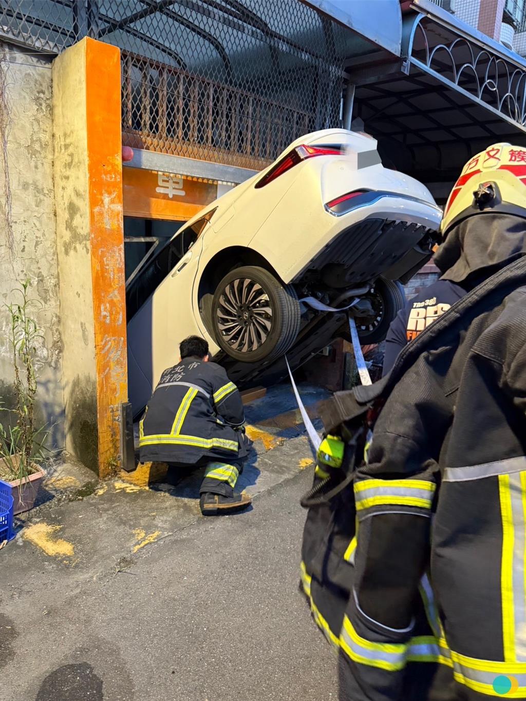 56歲黃姓男子今（28）日下午6時許開車返回新北市三峽區大仁路上的住所時，疑因停車場機械停車位故障，導致車輛「倒頭栽」卡在停車場入口，所幸人員平安。（翻攝畫面）