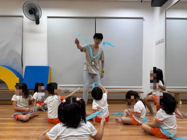 南華大學幼教系赴新加坡實習，陳宥諭同學運用魔術和彩帶，引導幼兒進行繞圈、飛舞的動作。(照片/南華大學提供)