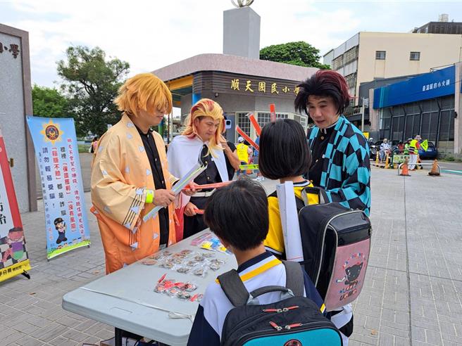 台中市警局大甲分局1日赴大甲區順天國小舉行護童專案，志工團扮演動畫「鬼滅之刃」經典角色，讓孩童又驚又喜。（温予菱攝）