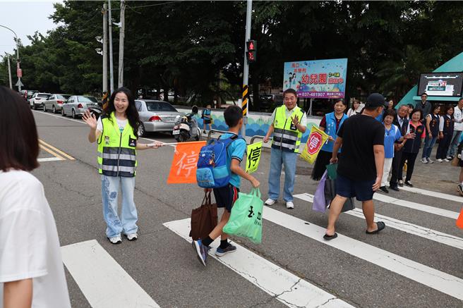 苗栗县114学年度第1学期于1日正式开学，苗栗县长锺东锦及夫人陈美琦一早便亲赴竹南镇海口国小，化身为导护志工，协助指引学生安全通过马路。（谢明俊摄）