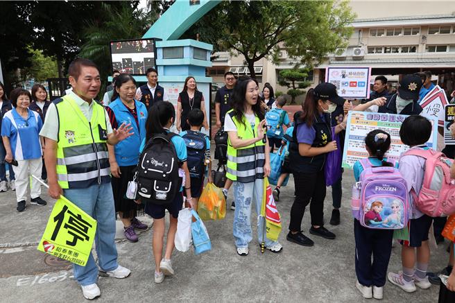 苗栗县114学年度第1学期于1日正式开学，苗栗县长锺东锦及夫人陈美琦一早便亲赴竹南镇海口国小，化身为导护志工，协助指引学生安全通过马路。（谢明俊摄）