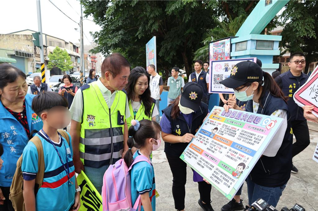 苗栗县114学年度第1学期于1日正式开学，苗栗县长锺东锦及夫人陈美琦一早便亲赴竹南镇海口国小，化身为导护志工，苗栗县警局所属5个分局也同步实施「护童专案」并由官警们向同学宣导校园安全观念。（谢明俊摄）
