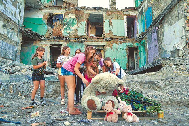 俄烏和談陷入僵局，美國總統川普已對談判失去耐心，俄方也將矛頭指向歐洲。圖為烏克蘭基輔的女孩們，在一棟被俄羅斯空襲摧毀的房屋前，擦拭泰迪熊身上的灰塵。（美聯社）