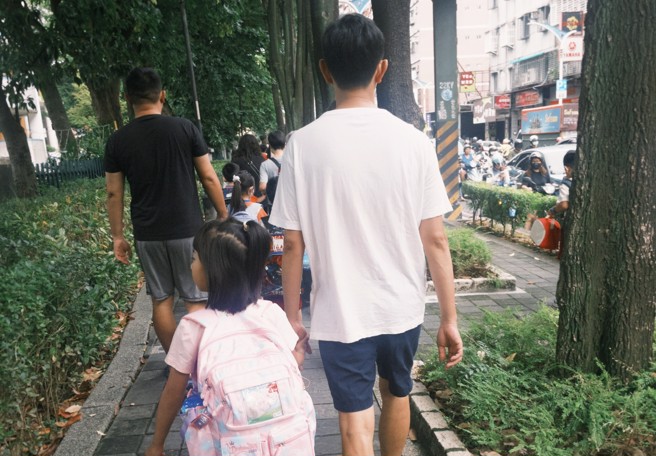 開學首日就有學生因發燒請假，醫師提醒目前正值6大病毒高峰期，家長須提高警覺，圖為開學日家長帶小一新生上課照。（記者楊雅婷／攝影）