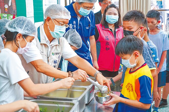 宜兰县代理县长林茂盛（左二）5日前往南屏国小了解营养午餐供应情形，并为学生打菜、与学生一起品尝营养午餐。（李忠一摄）