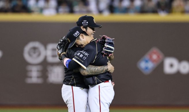 林智勝（左）在引退賽結束後，與二壘老搭檔郭嚴文相擁。（味全龍提供）