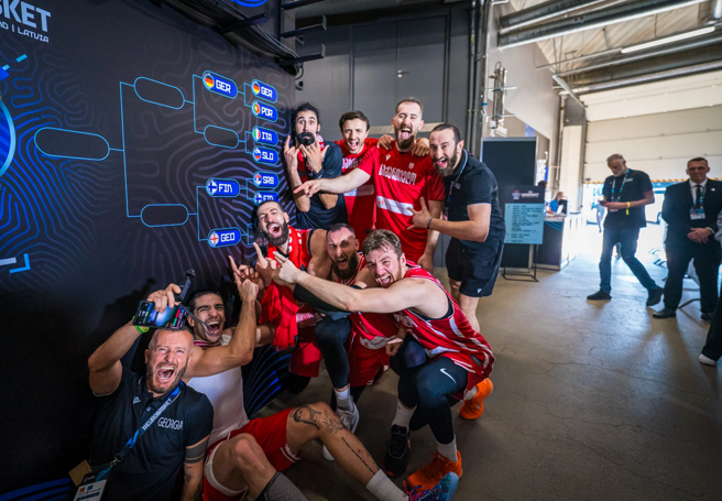 喬治亞球員興奮指著球隊晉級8強的牌子慶祝。(取自FIBA官網)