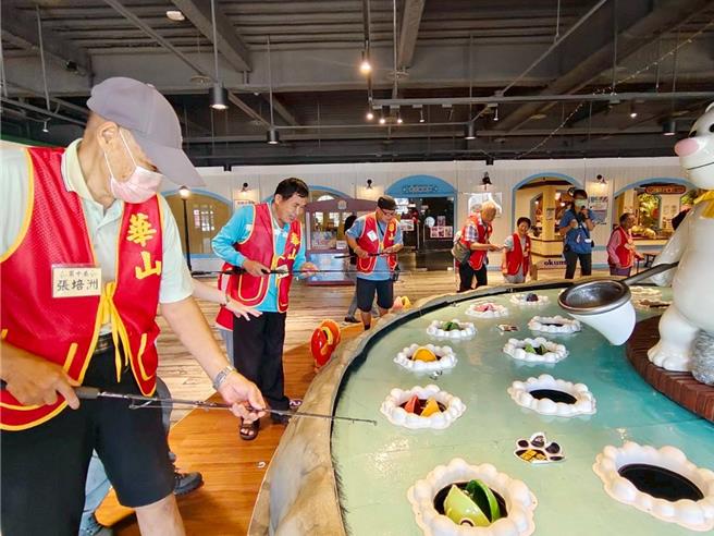 长辈们开心玩钓鱼机。（华山基金会提供／李京升台中传真）