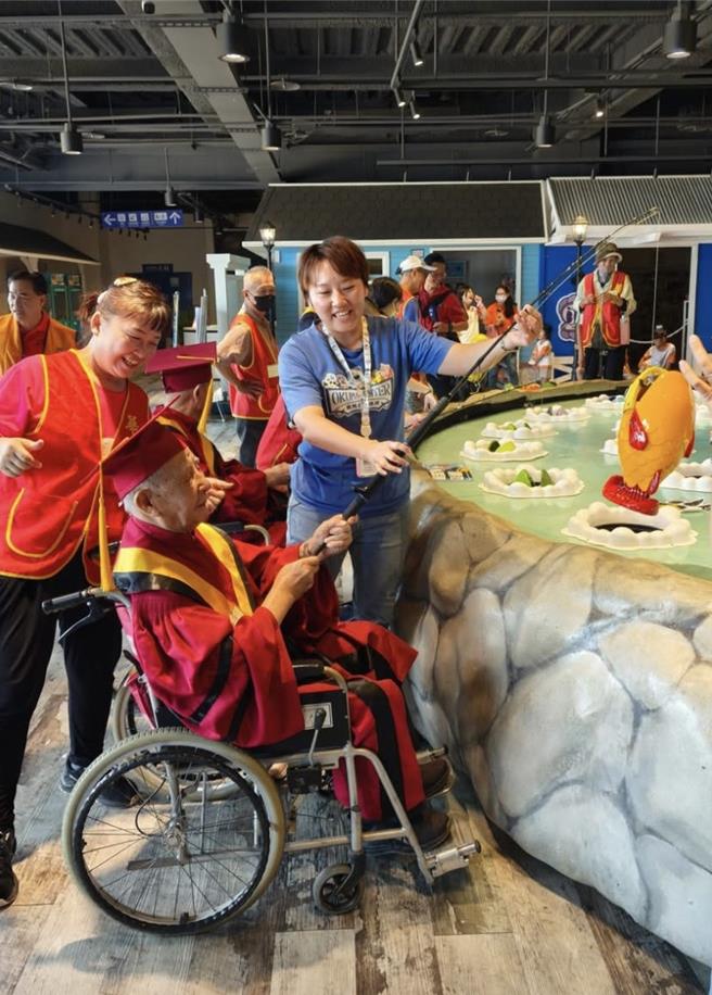 长辈们开心玩钓鱼机。（华山基金会提供／李京升台中传真）