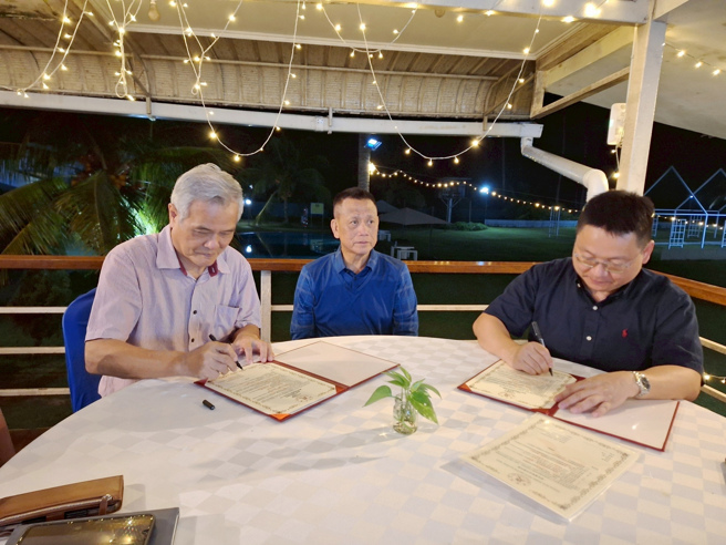 南華大學科技學院陳柏青院長(右)與馬來西亞「騰達生態農業科技公司」葉茂生執行長(左)簽署產學合作，保佛縣漁業處處長Primus bin Lukas(中)見證簽約儀式。(照片/南華大學提供)