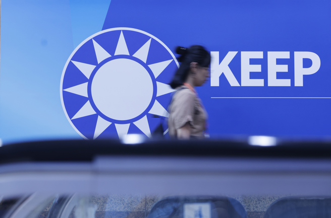 圖為民眾經過國民黨黨徽。（資料照／陳信翰攝）